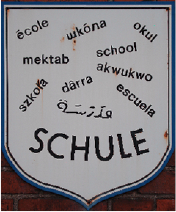 Ein Schild mit dem Schriftzug Schule in verschiedenen Sprachen